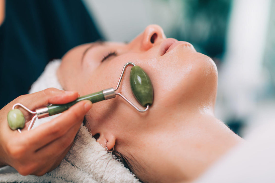 a woman getting a jade roller treatment on her face