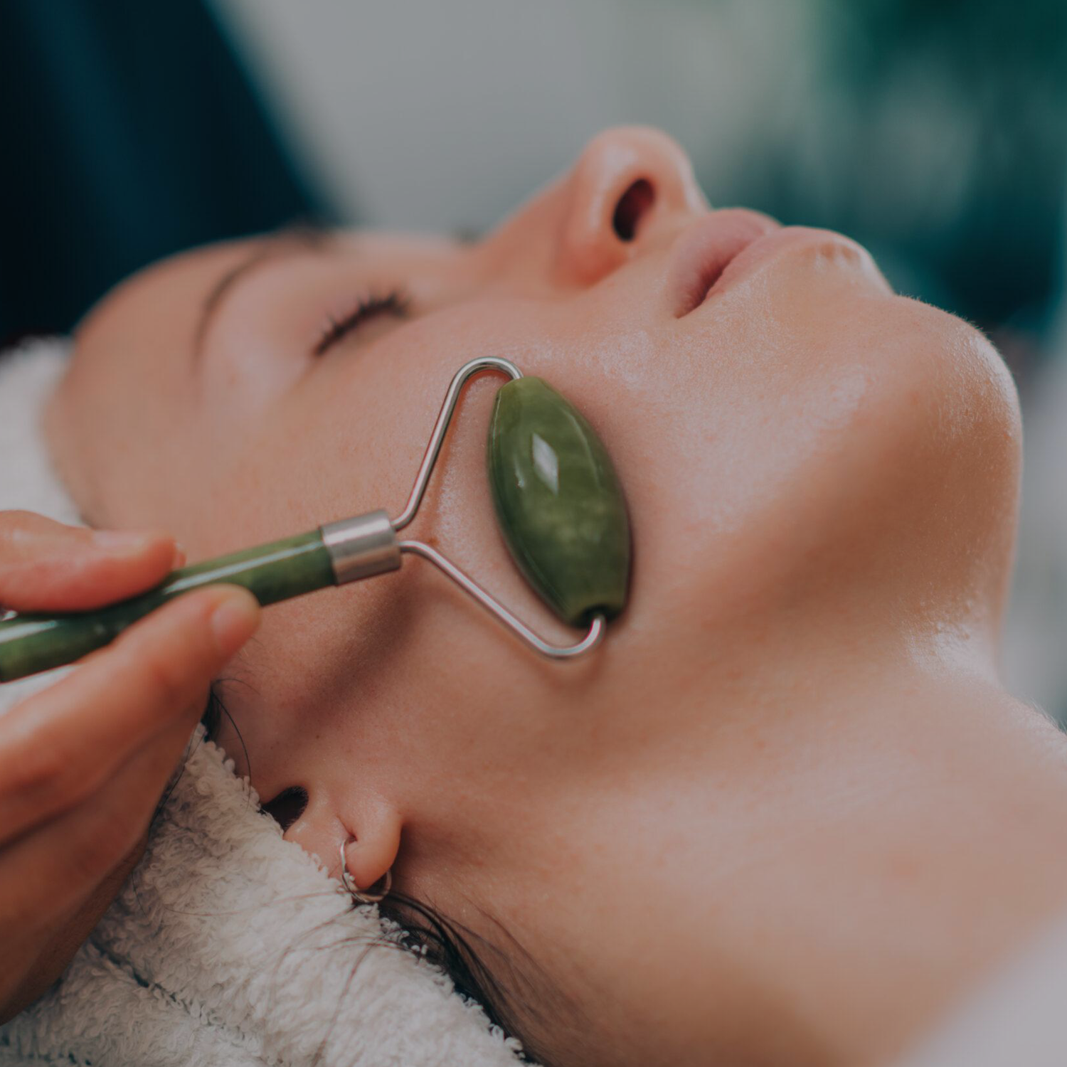 a woman having a jade roller treatment on her face