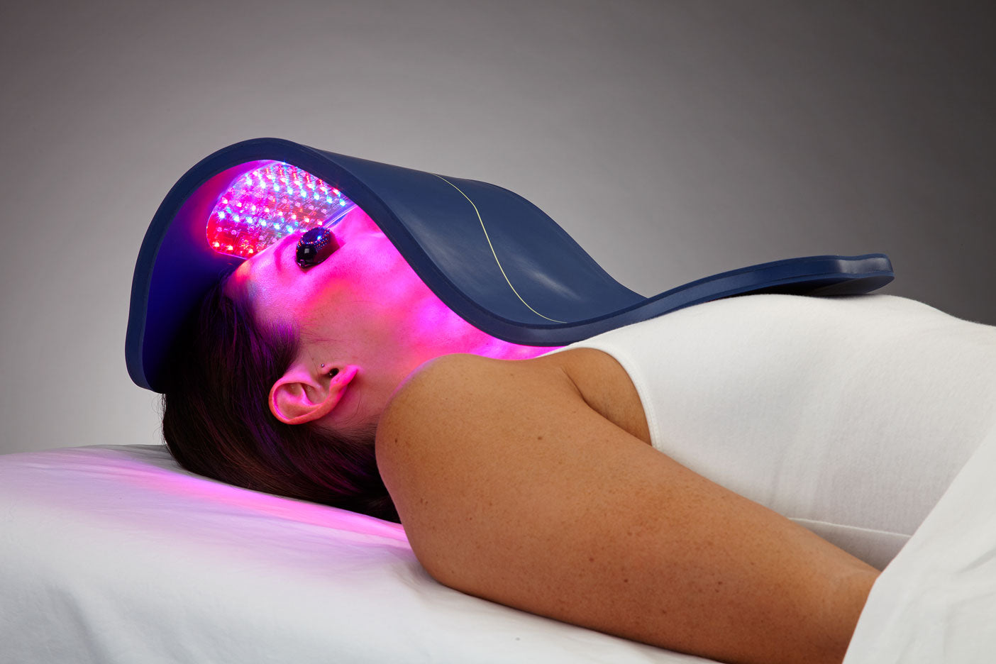 a woman laying down and having a red light therapy treatment