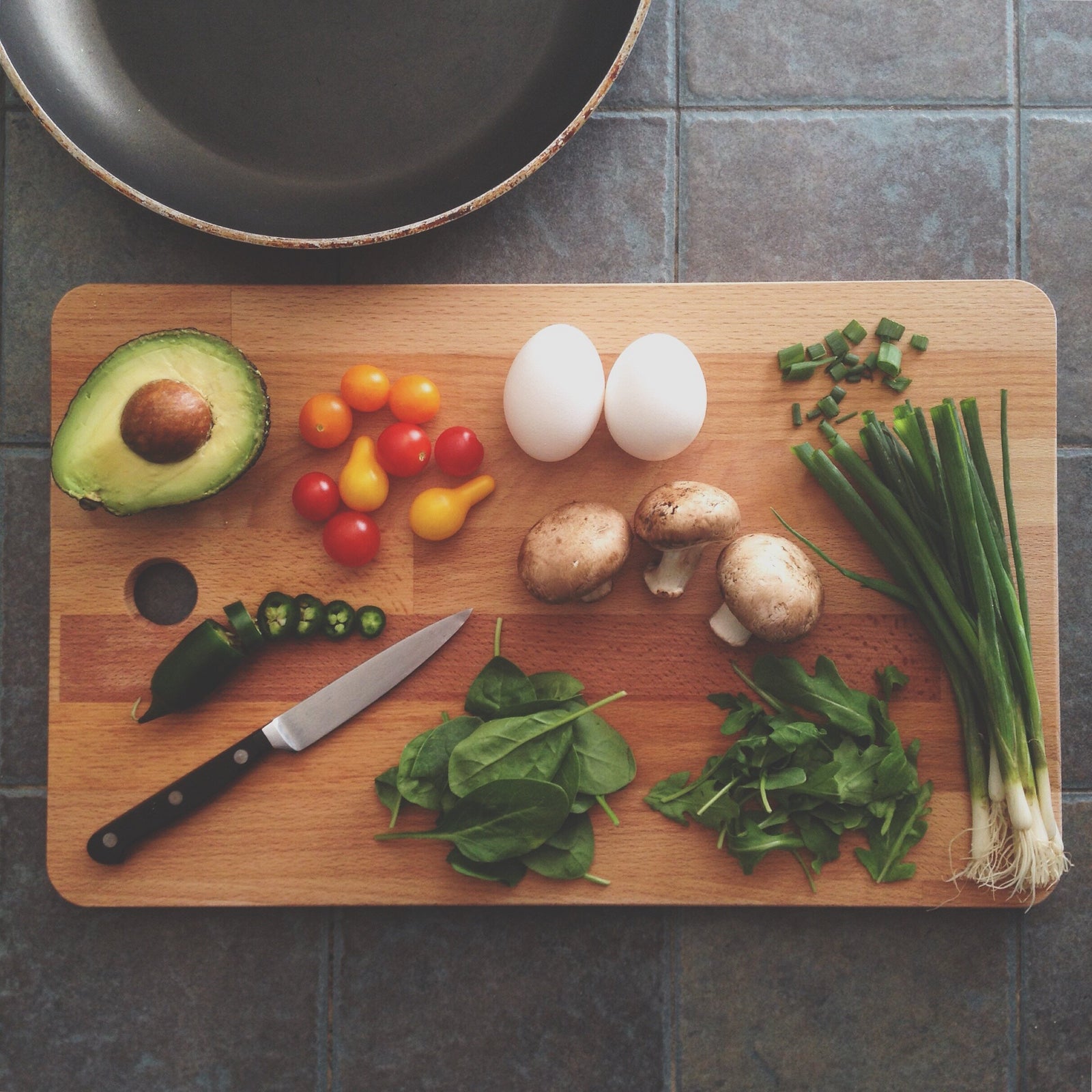 a photo of fruits and vegetables on a wooden cutting board